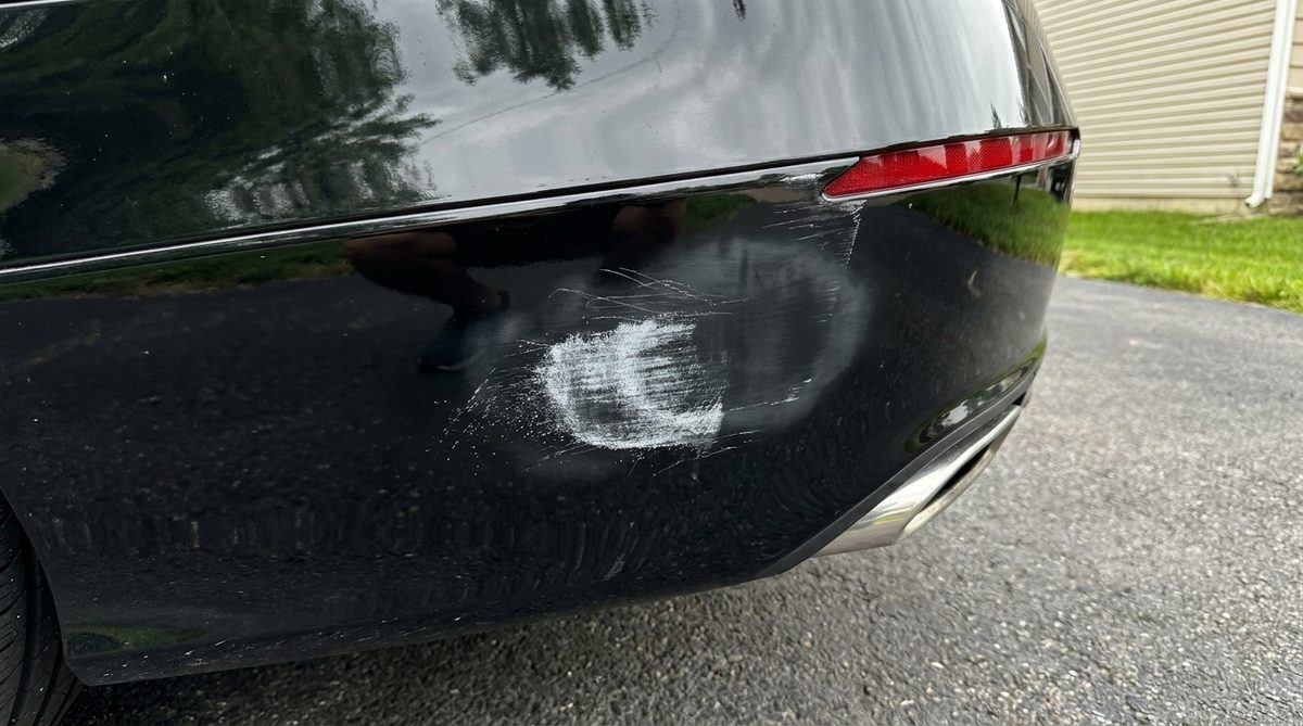 The same bumper corner after the compound, the shine gone out of the paint over the scuff.